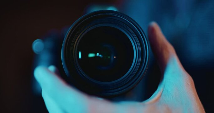 Photographer turning focus wheel on DSLR camera lens