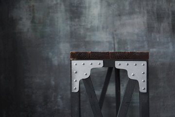 Wooden table with metal inserts. Loft style table on the background of a dark wall in grunge and loft style
