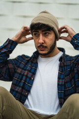 Chico atractivo joven con barba con ropa casual y camisa con skate