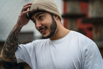 Chico atractivo joven con barba con ropa casual y camisa con skate