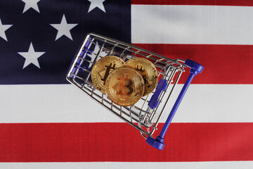 Three golden bitcoins in a supermarket cart, top view, selective focus