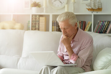  senior man using laptop at home
