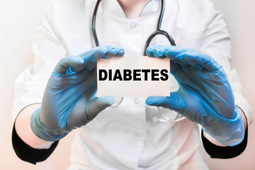 The doctor's blue - gloved hands show the word DIABETES - . a gloved hand on a white background. Medical concept. the medicine