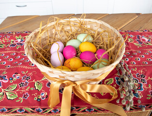 Colorful eggs inside the nest near pussy-willow on the festive wooden table