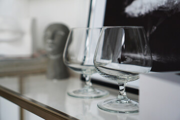 Empty glasses for whiskey on the background of a modern interior in a study or art gallery.