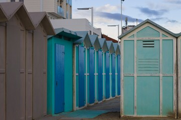 Blue beach sheds on the sand in a winter day (Pesaro, Italy, Europe)