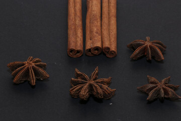 Cinnamon, anise, and coffee beans isolated on a black background.
