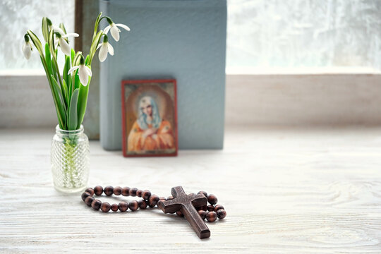cross, rosary beads, flowers, orthodox icon and bible books. concept of faith, God, orthodox Church Holiday, lent. soft focus