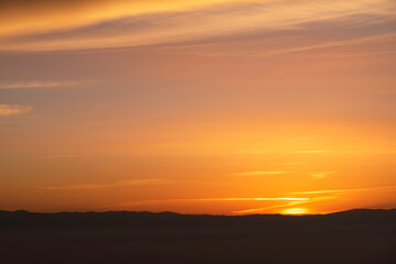 Fototapeta na wymiar Beautiful panoramic bright sunset over the mountains silhouette.