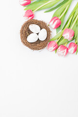 Obraz na płótnie Canvas Flat lay easter composition with pink tulips and eggs on white background