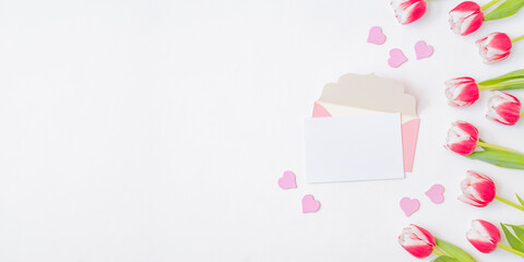 Mockup white greeting card and envelope with pink tulips on a white background