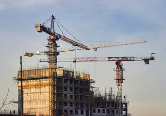 tower cranes on the construction site of multi-storey residential buildings