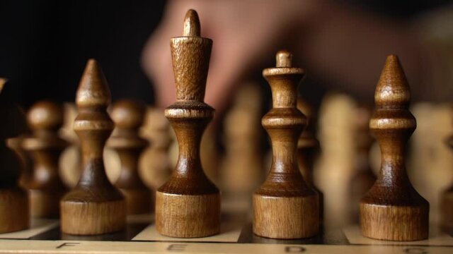 Close up of white and black chess pieces on board. Selective focus on first move of white pawn on chessboard. Concept of intelligent, logical and strategic game.