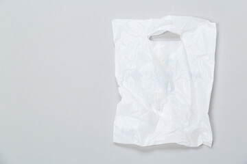 Clear disposable plastic bag on grey background. Space for text