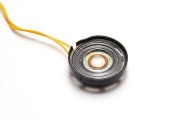 Miniature speaker with connected wires on a white background.