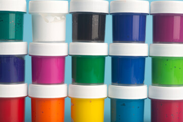 Acrylic paint of different colors on a blue background. Paint for painting