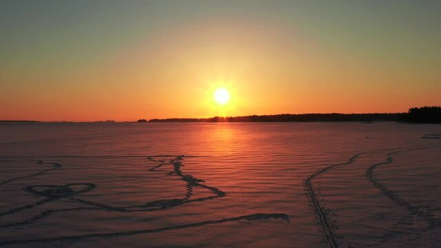 Aerial view of sunrise over the ice-covered Baltic Sea in winter.