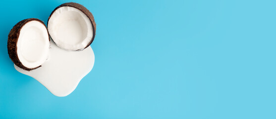 Coconut cream or butter with fresh coconuts on a blue banner background. White cream juice dripping from coconut.