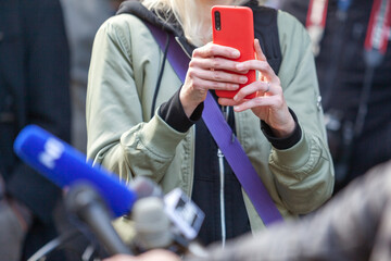 Press or news conference, mobile journalist filming media event with a smartphone