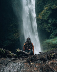 mujer frente a cascada natural