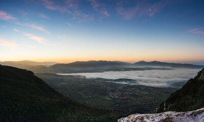 Sunrise from the top of the mountain with fog on the valley, Terni, Umbria, Italy