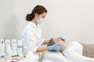 Obraz na płótnie Canvas Cosmetologist doing facial massage to a girl