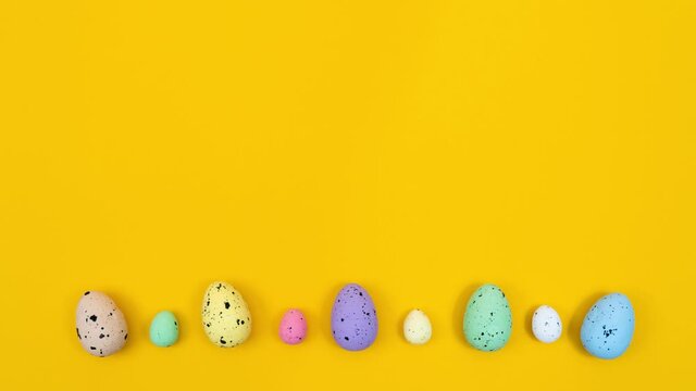 Animation of a little chicken jumping on colored eggs on a yellow background