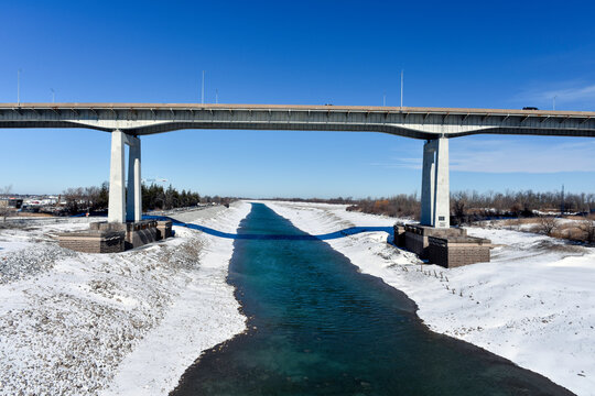 The Welland Canal is drained for the winter, allowing maintenance to be completed. St. Catharines Garden City Skyway runs above.