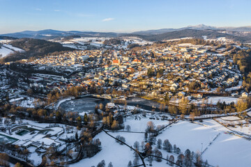 Bild einer Luftaufnahme mit einer Drohne der Stadt Grafenau im bayerischen Wald mit Bergen Arber Rachel und Lusen im Winter mit Schnee und Eis, Deutschland