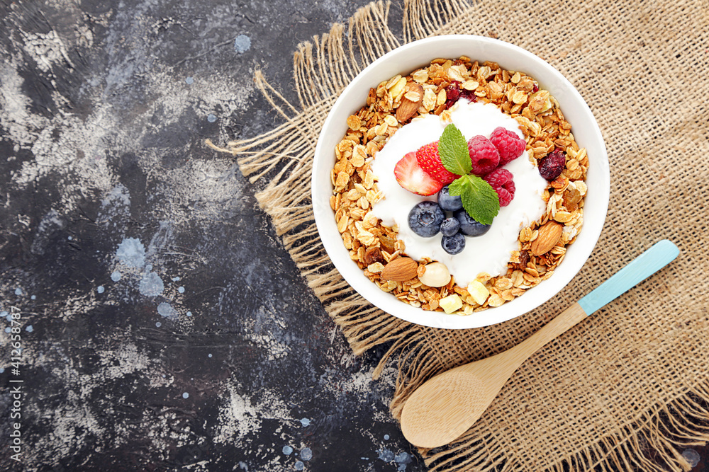 Poster Tasty granola with fresh berries on grey background