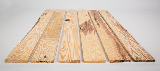 Unfinished raw pine lumber with light and dark color variation on a solid white background