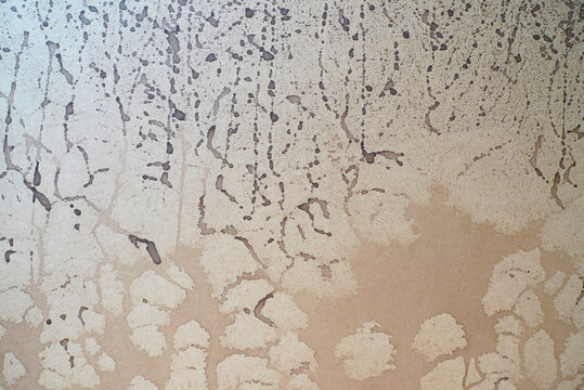 Bloated plywood splattered with brown ink 