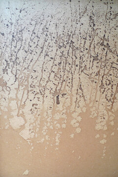 Bloated plywood splattered with brown ink 