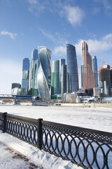 Fototapeta na wymiar City landscape in sunny winter day with the view of the Moscow-City buildings and frozen river