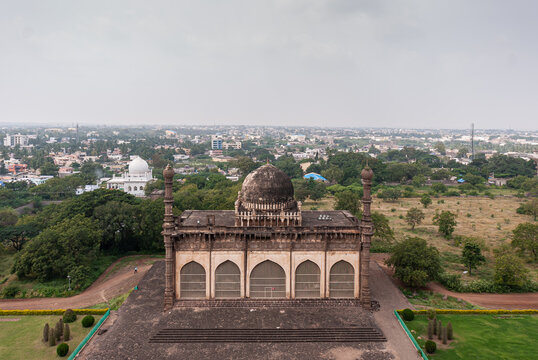 Vijayapura, Karnataka, India - November 8, 2013: Gol Gambaz Mausoleum. Aerial view from top on Majhid or mosque with its blackened dome and 2 minarets. White Hazrat Hashim Peer Dargah.