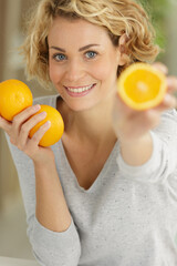 a woman is holding oranges