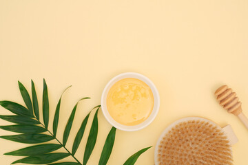 Composition of ingredients for anti-cellulite treatments. Natural organic honey, wood brush for dry body massage. Honey scrub. Flat lay, top view, copy space