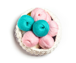 Fototapeta na wymiar Pink and blue skeins of wool yarn on a white insulated background. Knitted basket with yarn