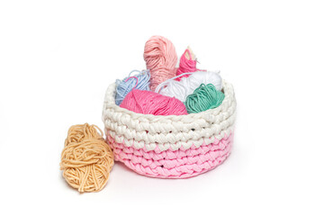Remnants of yarn in a woven textile basket on an isolated background. Everything for manual work