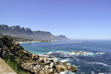 Beautiful view of the beach in Cape Town. Rocks, the sea and Twelve Apostles Mountain Range in the background.