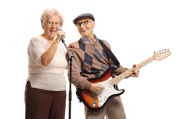 Fototapeta premium Elderly woman with a microphone and an elderly gentleman playing a guitar