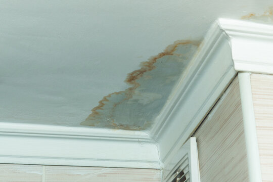 Neighbors have a water leak, water-damaged ceiling, close-up of a stain on the ceiling