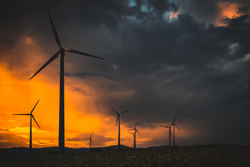 wind turbines at sunset in bad weather