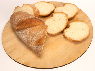Close up of sliced baguette on cutting board in kitchen. Chopped white bread on wooden board . High quality photo