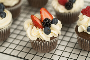Cupcake decorado con betún y frutas frescas (fresa, blueberry)