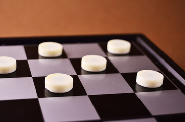 White magnetic checkers on the playing field close up with copy space. High quality photo
