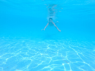 boy swimming in pool with blue water in vacation