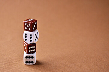 The white and brown dice stand on top of each other with a copy space. High quality photo