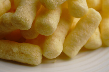 Corn sweet sticks very close on a white plate. Golden color.