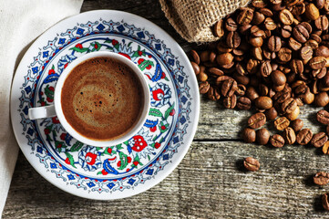 Turkish coffee concept, cup of coffee with coffee beans on wooden background